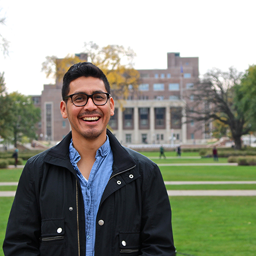 Jose Palma, grad student, outside with the grassy Mall and Northrop Memorial Auditorium in the background