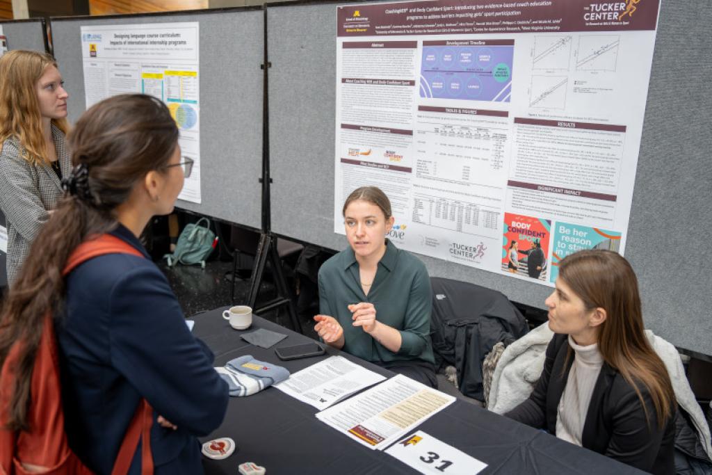 Attendees having a conversation at research booth