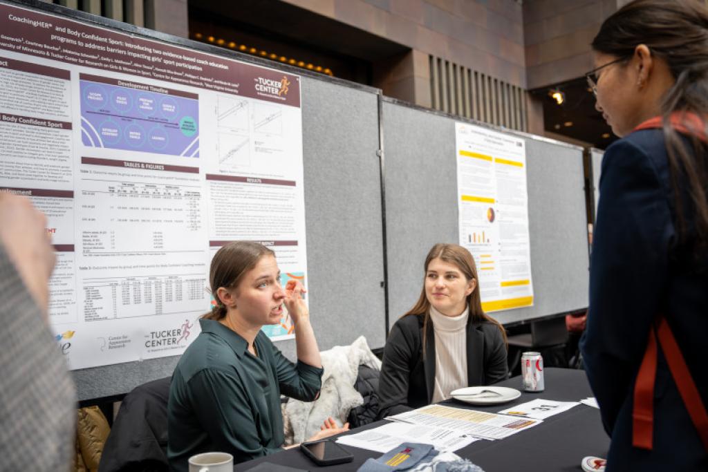 Attendees having a conversation at research booth