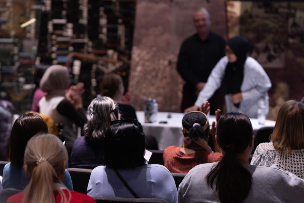Attendees watching research presentation