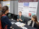 Attendees having a conversation at research booth 