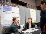 Attendees having a conversation at research booth 